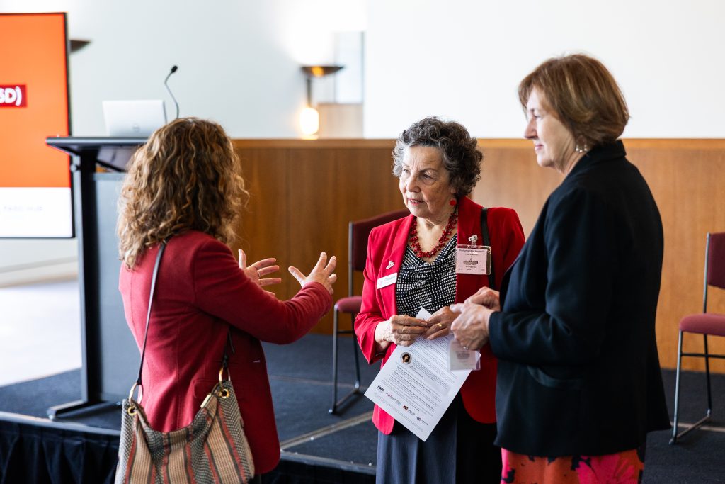 Three women talking together at an event.