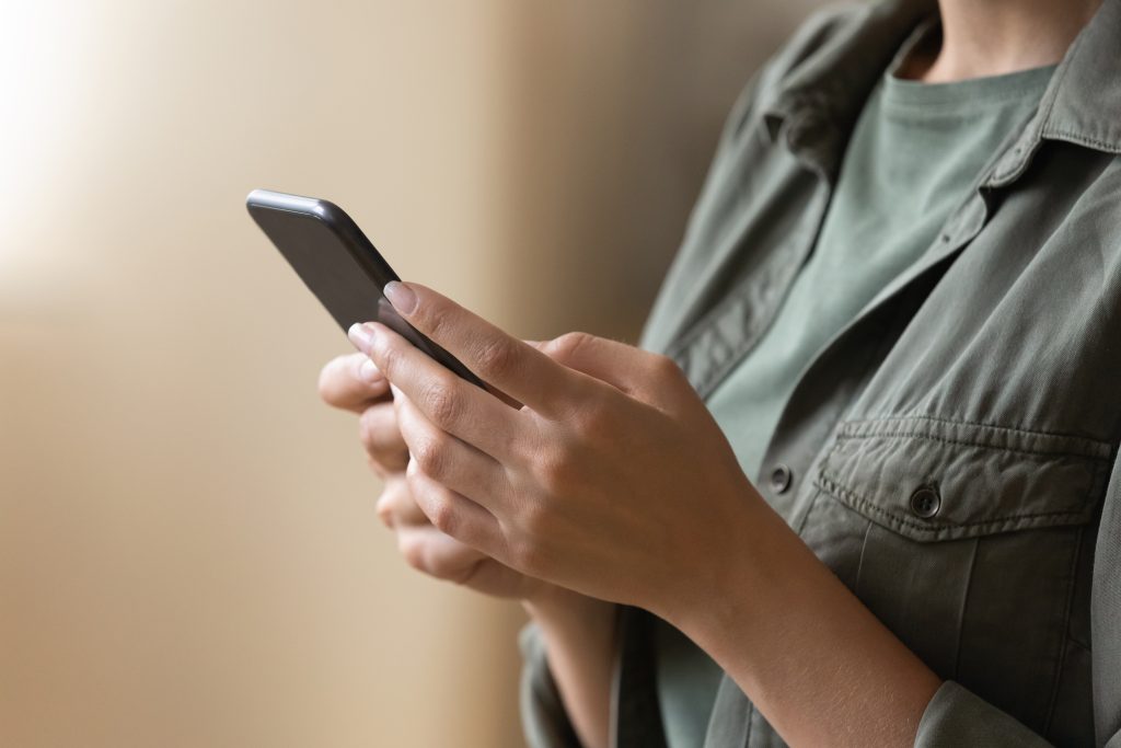 Close up of a woman holding a phone and reading the screen.